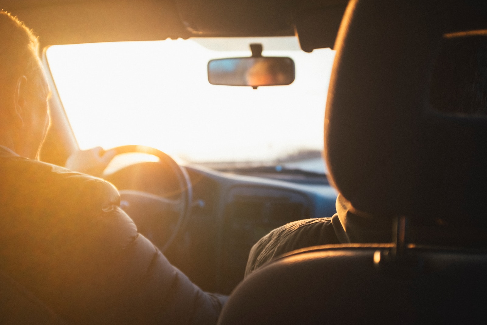 man driving car during golden hour, auto insurance